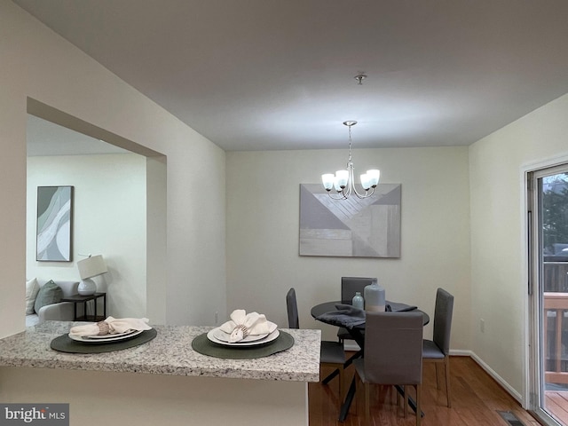 dining room featuring an inviting chandelier and hardwood / wood-style flooring