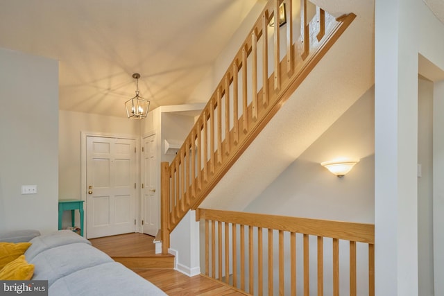 entryway with light wood-style flooring, stairway, and a notable chandelier