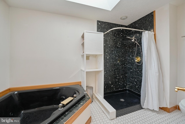 bathroom with a skylight, a shower stall, and toilet