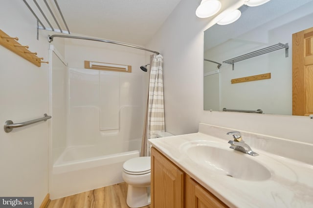 bathroom featuring shower / bathtub combination with curtain, toilet, a textured ceiling, vanity, and wood finished floors