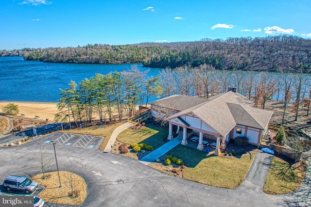 drone / aerial view featuring a water view and a forest view