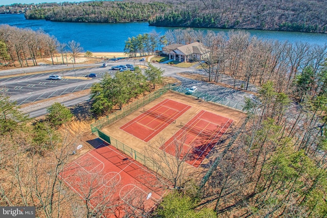 bird's eye view with a water view and a wooded view