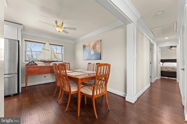 dining room with a ceiling fan, baseboards, dark wood-style floors, attic access, and crown molding