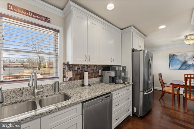 kitchen with white cabinetry, crown molding, appliances with stainless steel finishes, and a sink