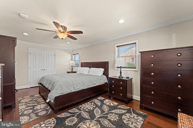 bedroom with dark wood-style floors, ornamental molding, a closet, and baseboards