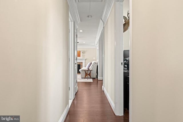 corridor with ornamental molding, dark wood finished floors, attic access, and baseboards