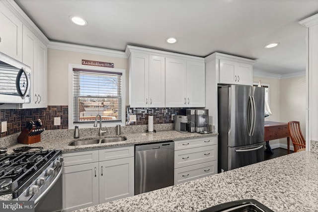 kitchen featuring stainless steel appliances, crown molding, a sink, and white cabinetry