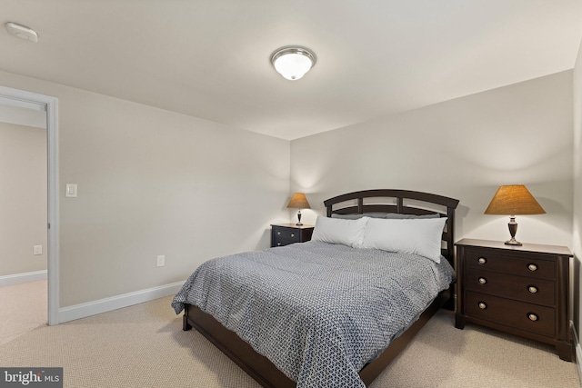 bedroom with light carpet and baseboards