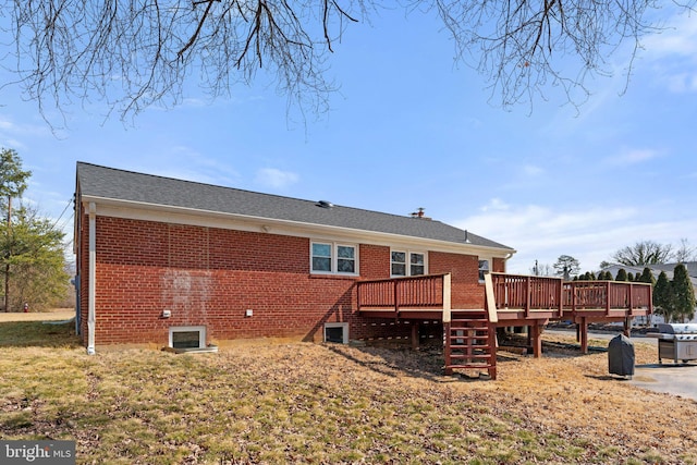 rear view of property with a deck and brick siding