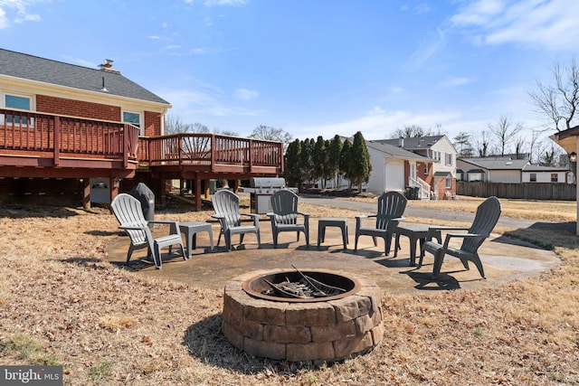 view of patio / terrace featuring fence, a fire pit, a deck, and area for grilling