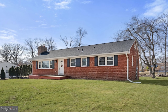 ranch-style home with a shingled roof, brick siding, a chimney, and a front lawn