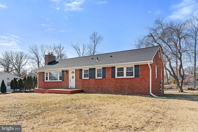 ranch-style home with a shingled roof, a front yard, brick siding, and a chimney