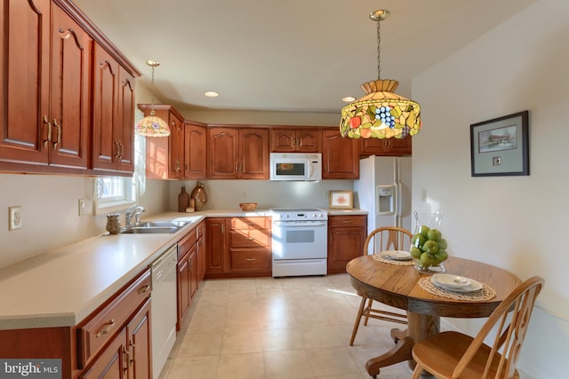 kitchen with sink, white appliances, and decorative light fixtures