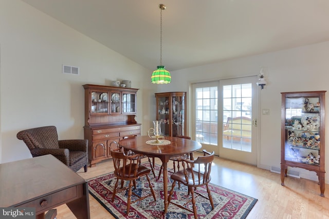 dining space with lofted ceiling and light hardwood / wood-style floors