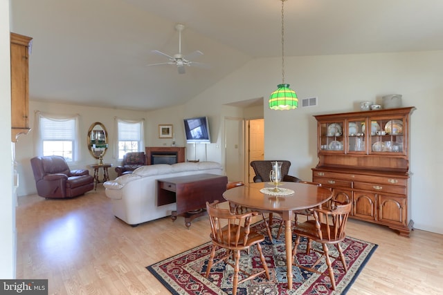 dining area featuring ceiling fan, lofted ceiling, and light hardwood / wood-style flooring