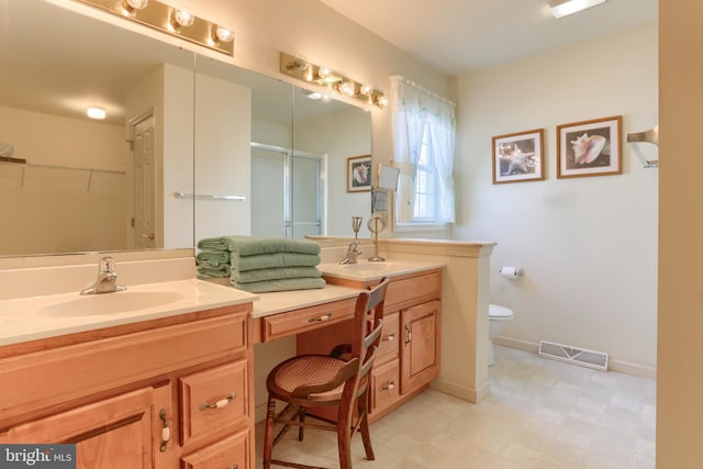 bathroom featuring vanity, an enclosed shower, and toilet