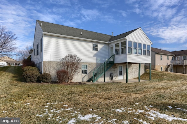 rear view of property with a yard, a sunroom, and a patio