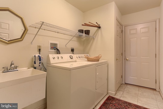 laundry room featuring sink, light tile patterned floors, and washer and clothes dryer