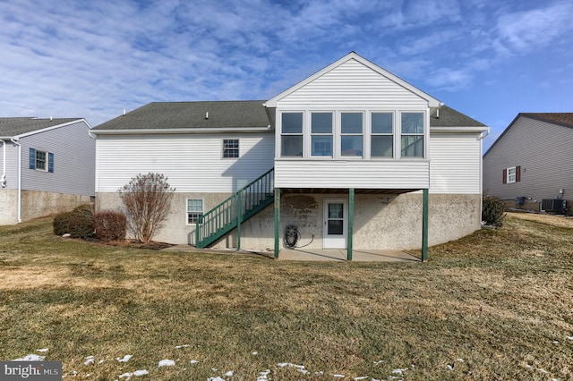 rear view of house with cooling unit, a yard, a patio area, and a sunroom