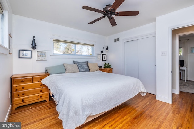 bedroom with ceiling fan, light wood-type flooring, and a closet