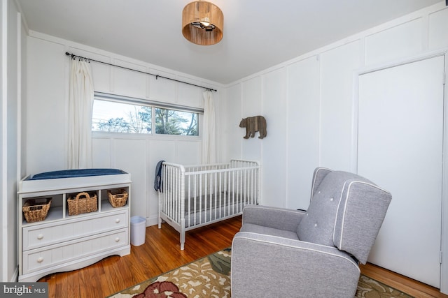 bedroom featuring hardwood / wood-style flooring and a nursery area