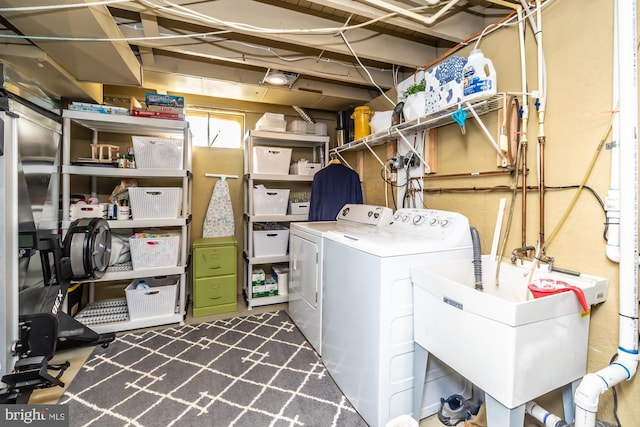 laundry area featuring washing machine and clothes dryer and sink