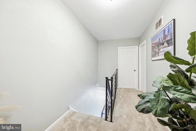 hallway featuring light carpet