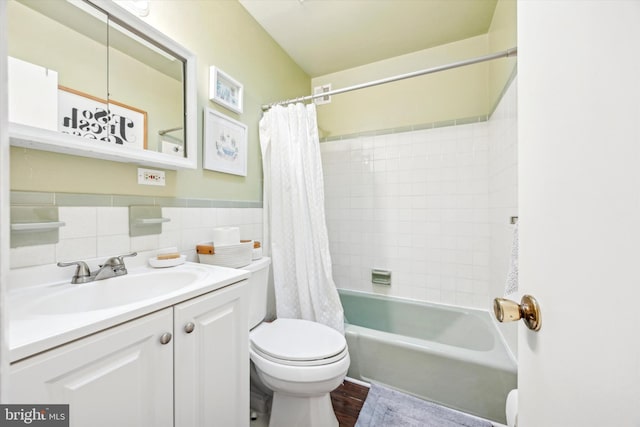 full bathroom featuring shower / tub combo with curtain, tile walls, vanity, wood-type flooring, and toilet