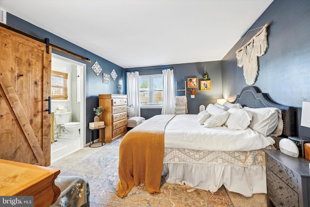 bedroom with ensuite bathroom and a barn door