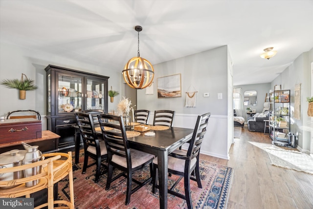 dining room with dark hardwood / wood-style flooring and a notable chandelier