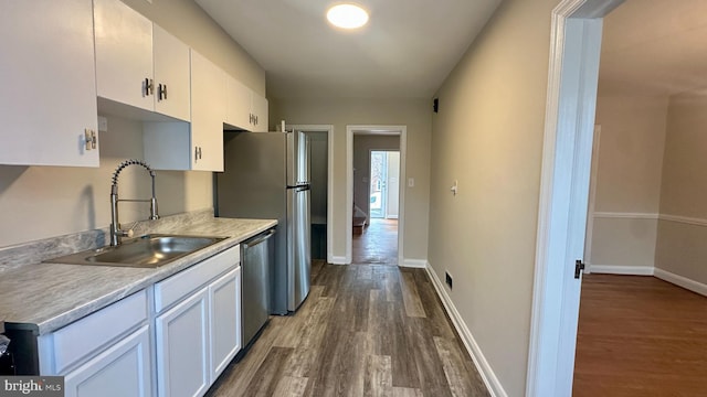 kitchen featuring stainless steel appliances, sink, dark wood-type flooring, and white cabinets