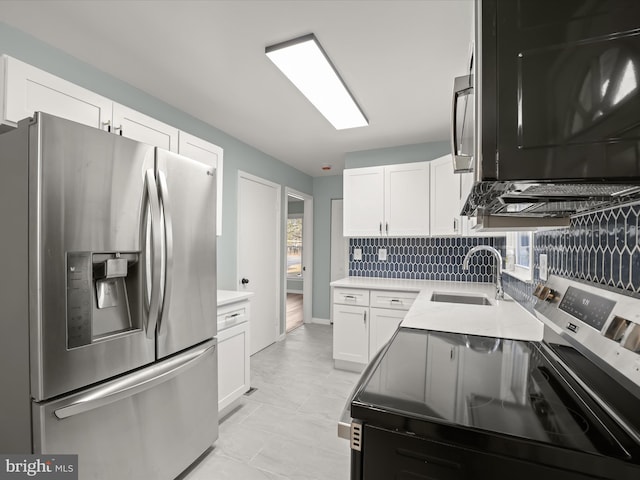 kitchen featuring white cabinetry, sink, backsplash, and appliances with stainless steel finishes