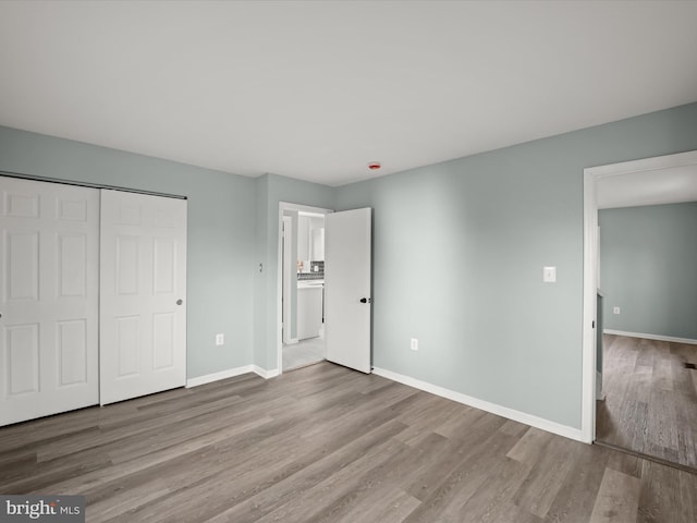 unfurnished bedroom with light hardwood / wood-style floors and a closet