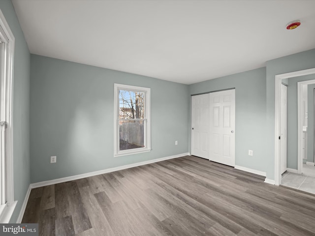 unfurnished bedroom with light hardwood / wood-style flooring and a closet