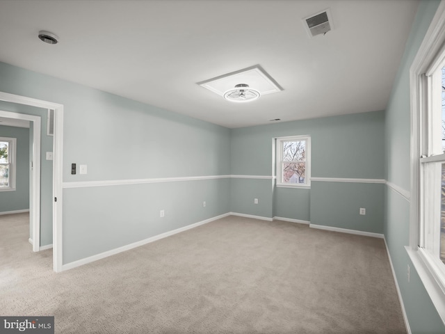 spare room featuring light colored carpet