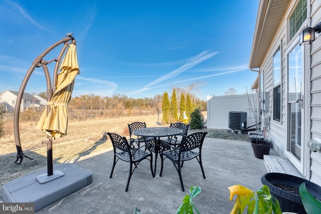 view of patio with fence, central AC, and outdoor dining space