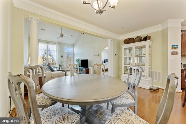 dining room with arched walkways, decorative columns, light wood finished floors, visible vents, and ornamental molding