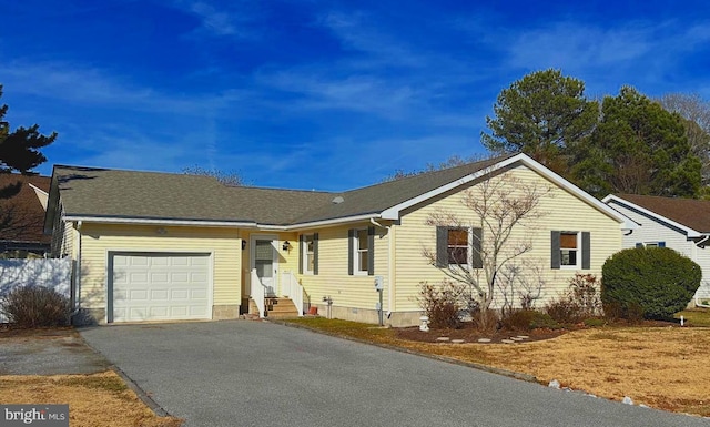 single story home with aphalt driveway, crawl space, and an attached garage