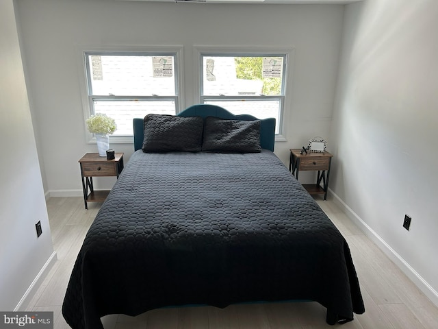 bedroom featuring light hardwood / wood-style floors and multiple windows