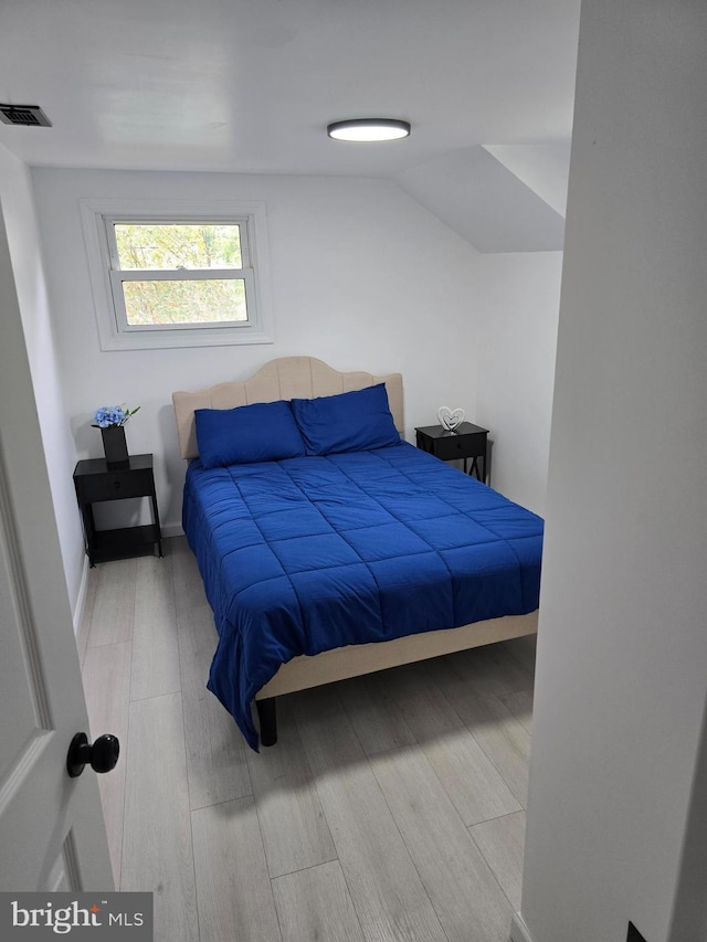 bedroom featuring vaulted ceiling and light hardwood / wood-style flooring