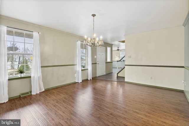 unfurnished room featuring ornamental molding, dark hardwood / wood-style floors, and ceiling fan with notable chandelier