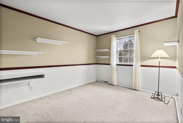 carpeted spare room featuring ornamental molding