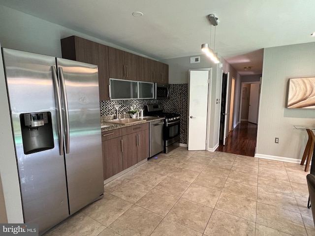 kitchen with dark brown cabinetry, sink, decorative light fixtures, and appliances with stainless steel finishes