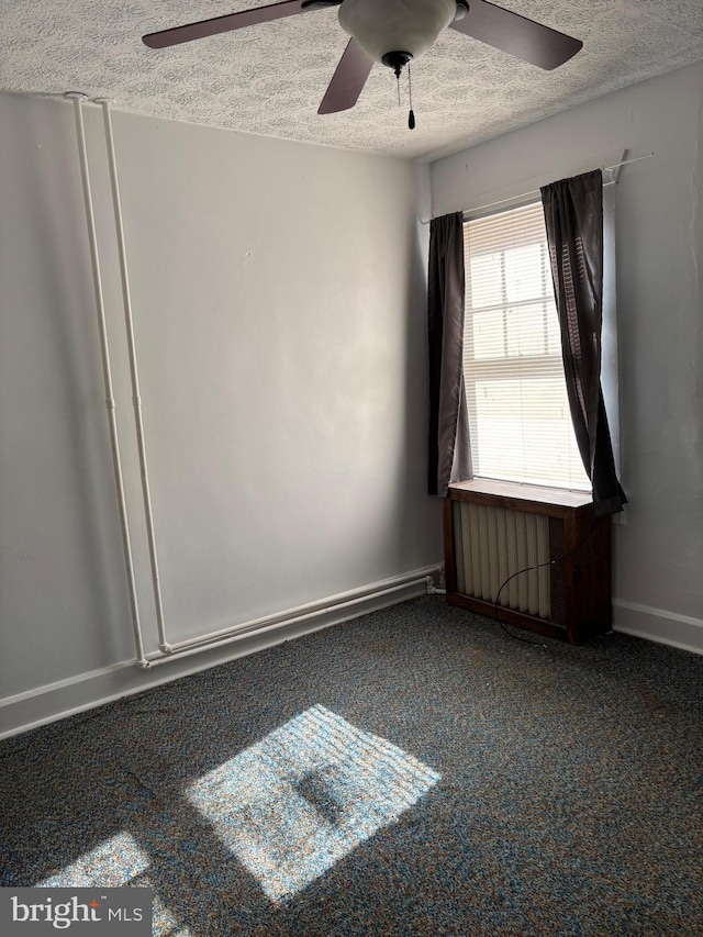 carpeted empty room with ceiling fan and a textured ceiling