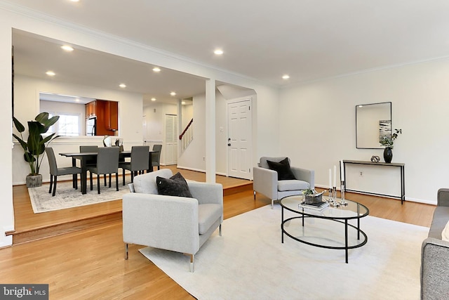 living room featuring light hardwood / wood-style flooring and ornamental molding