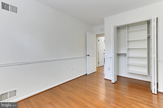 unfurnished bedroom featuring light wood-type flooring and a closet