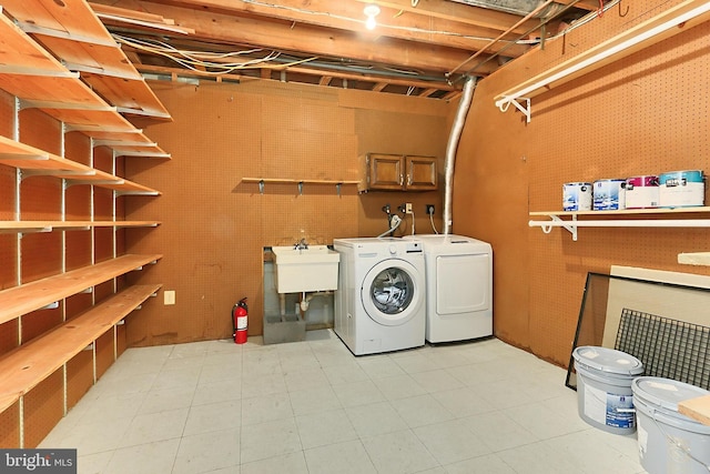 washroom featuring a workshop area, cabinets, sink, and washer and dryer