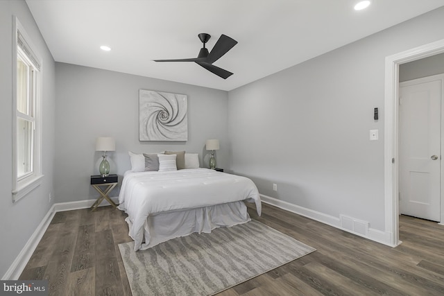 bedroom with dark hardwood / wood-style floors and ceiling fan