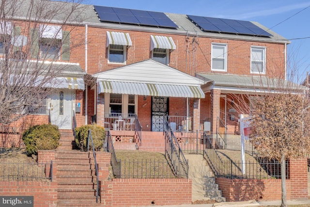 view of front of house with covered porch and solar panels