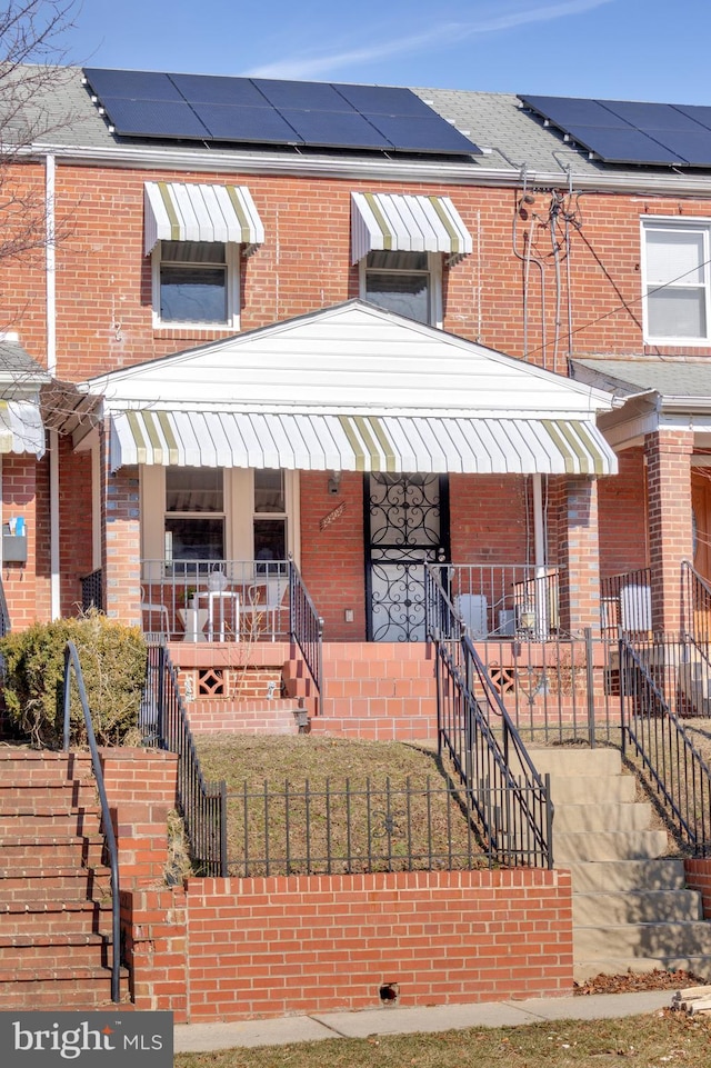 view of front facade with a porch and solar panels